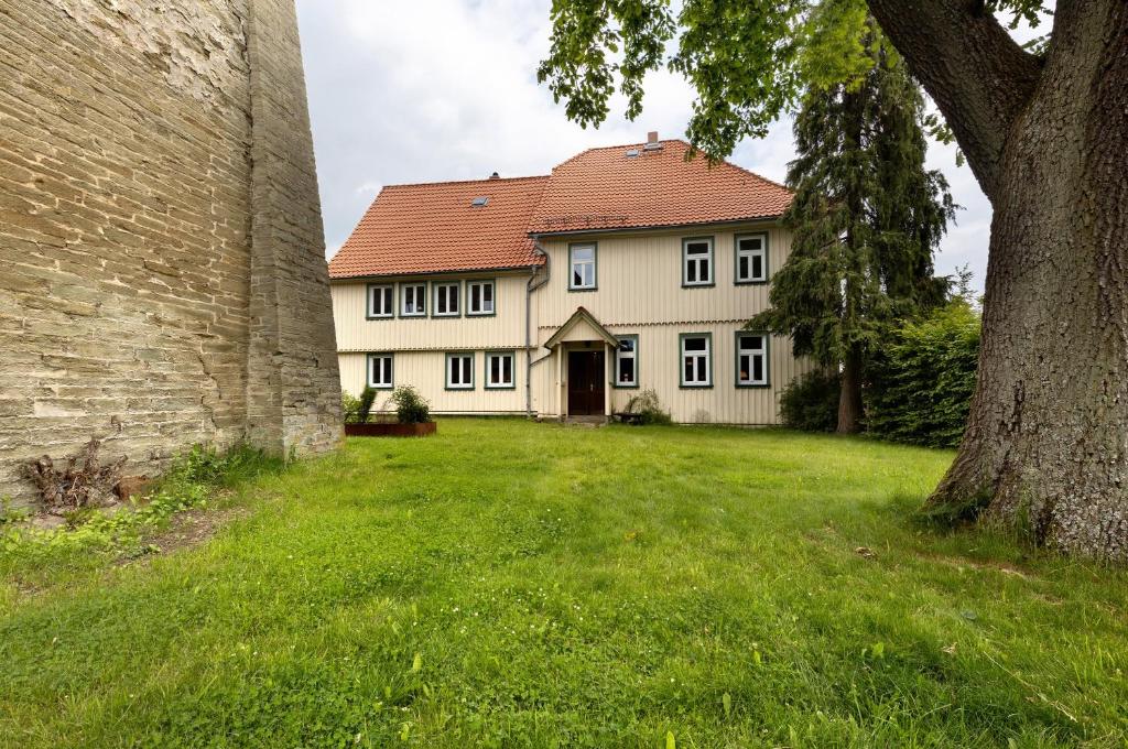 a large white house with a red roof at Altes Pfarrhaus - Wohnung Farbwelt in Hüttenrode