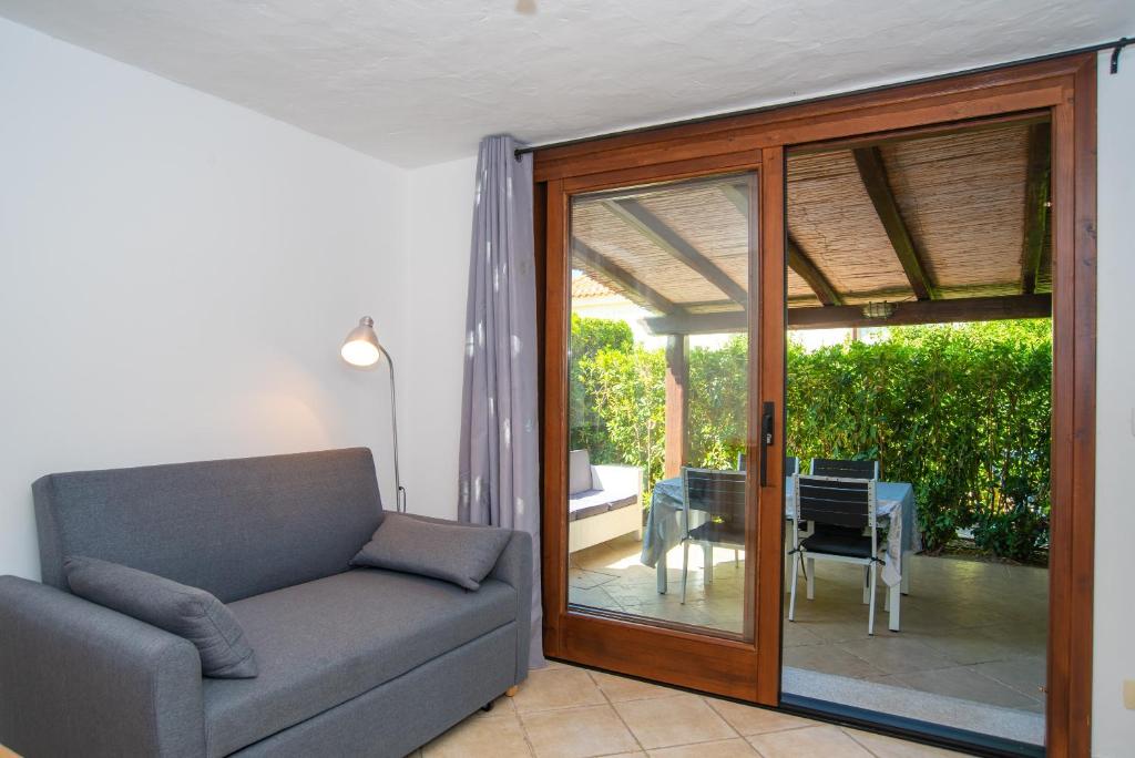 a living room with a couch and a sliding glass door at Appartamento del Cormorano in Olbia