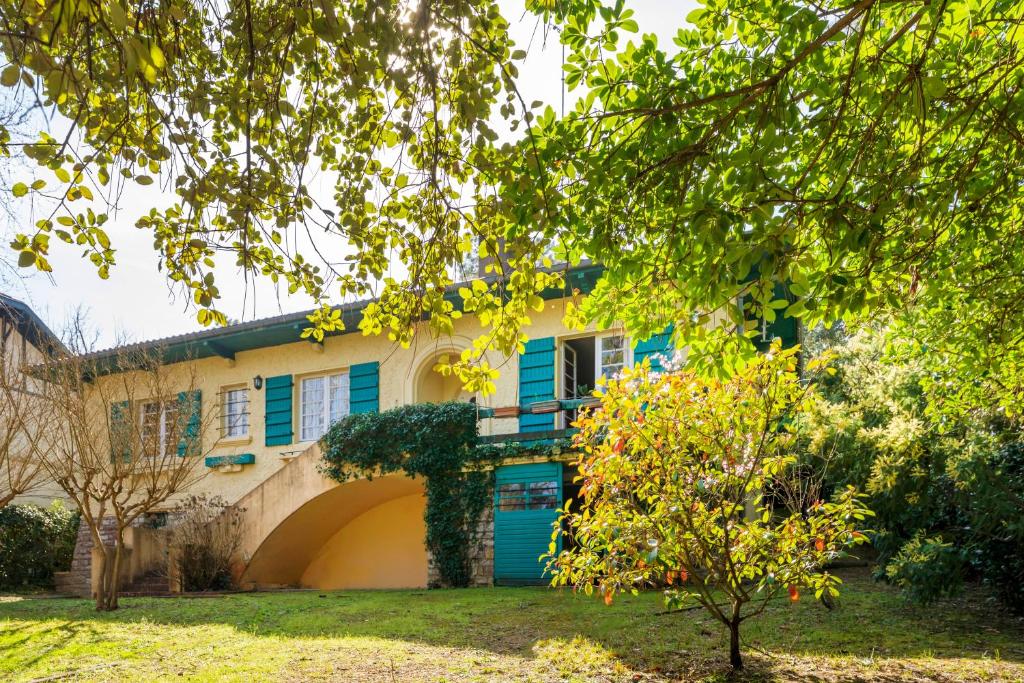 a house with a blue door and a tree at Villa Eole - plein centre Hossegor in Soorts-Hossegor