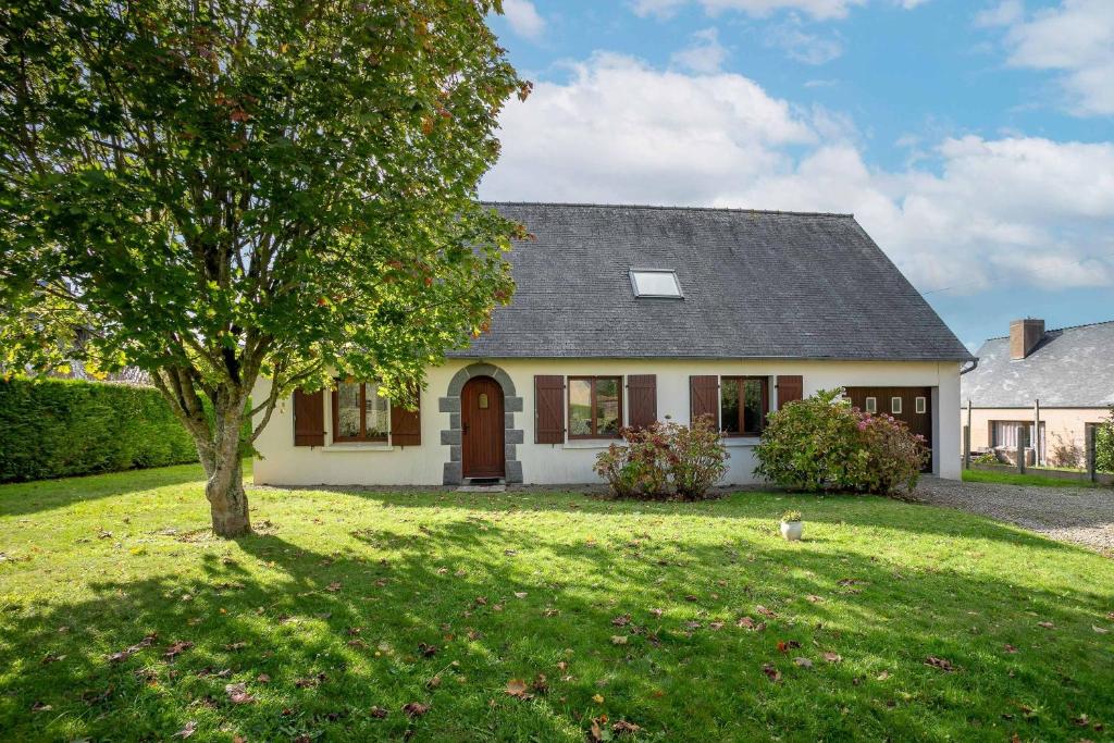 a white house with a tree in the yard at Maison familiale Kerriou in Plestin-les-Grèves