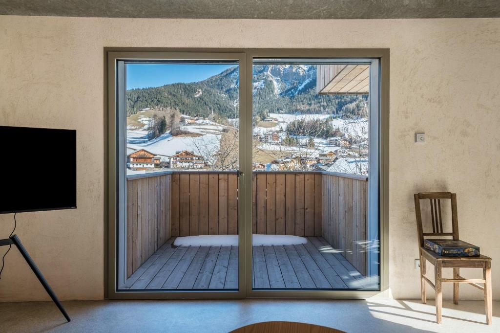 a room with a balcony with a view of a mountain at Lena Dolomites Suite in Villnoss