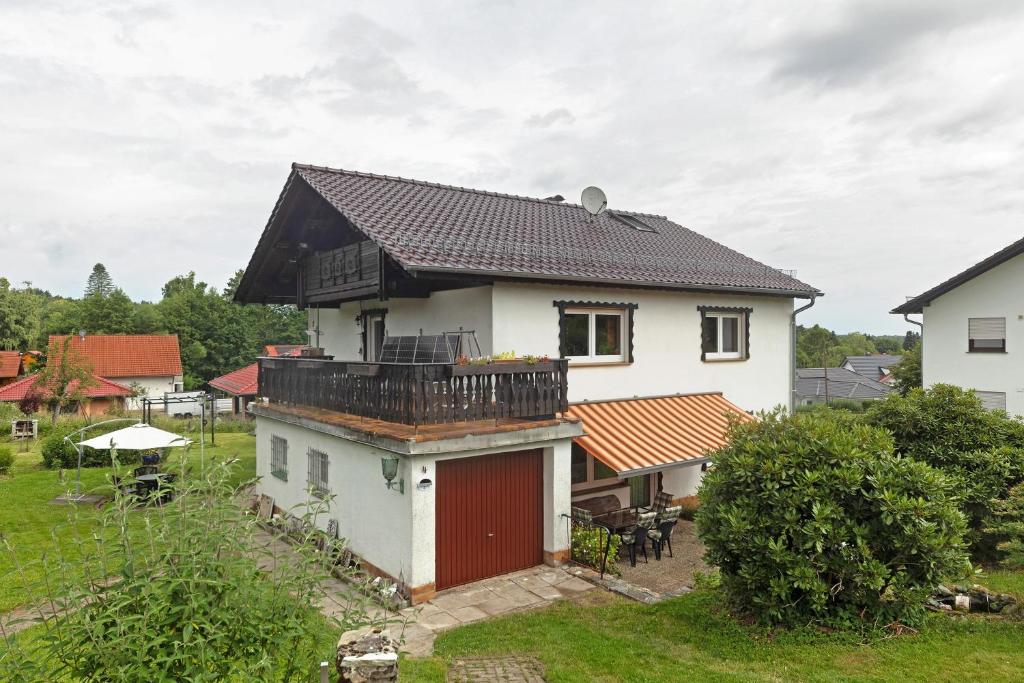 a house with a red door and a balcony at Ferienwohnung Eva in Grebenhain