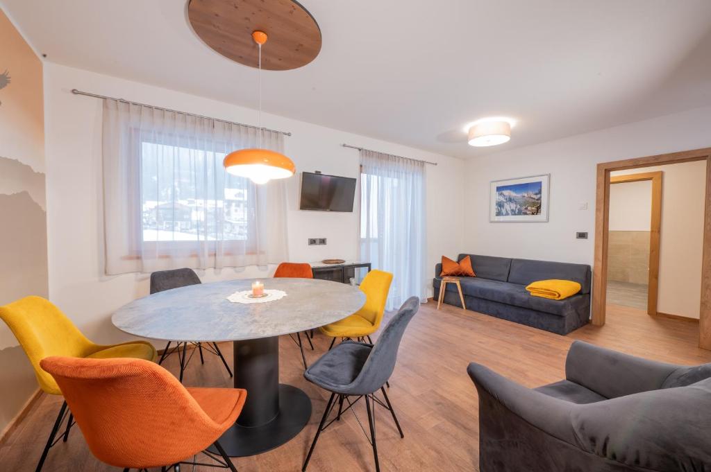 a living room with a table and chairs at App. Miara - Ciasa Lavarella in San Vigilio Di Marebbe