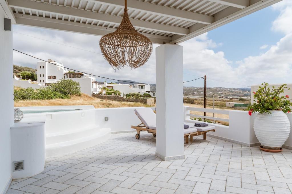 a patio with a chandelier and a chair on a roof at Aeolos Villa Erato in Agkidia
