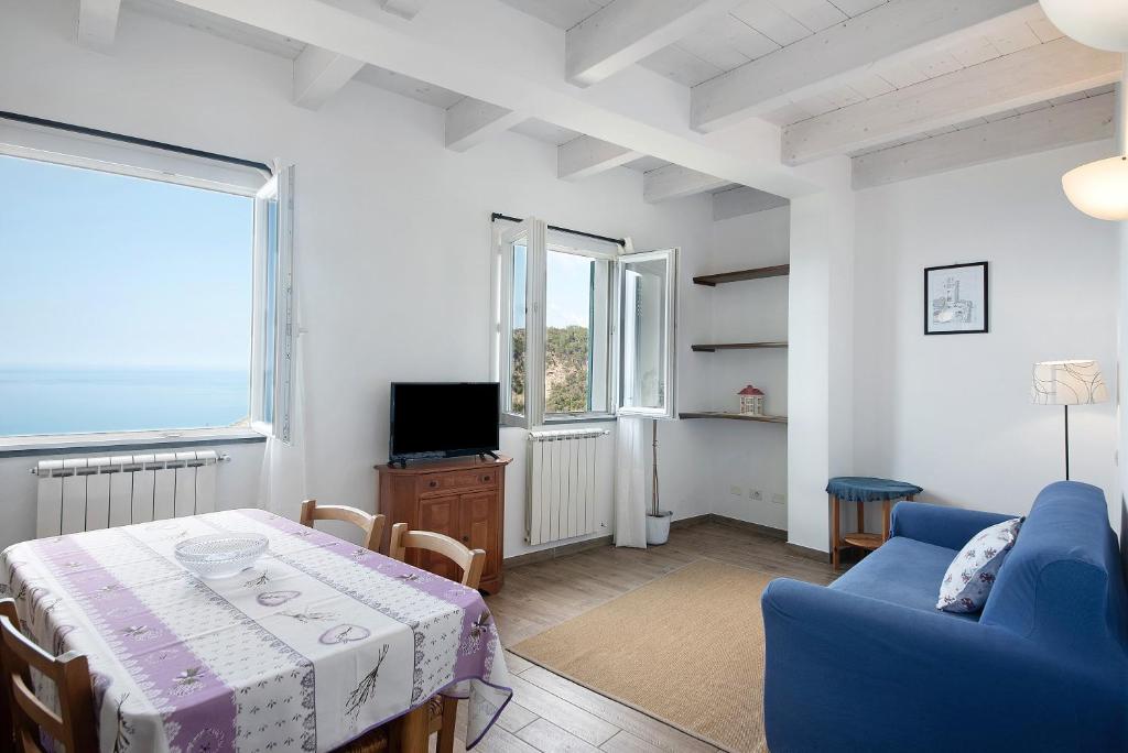 a living room with a table and a blue couch at Casa mare montaretto 1 in Bonassola