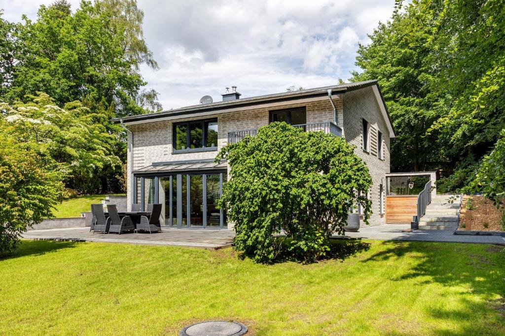 a brick house with a patio in the yard at Studio mt nine in Neu Wulmstorf