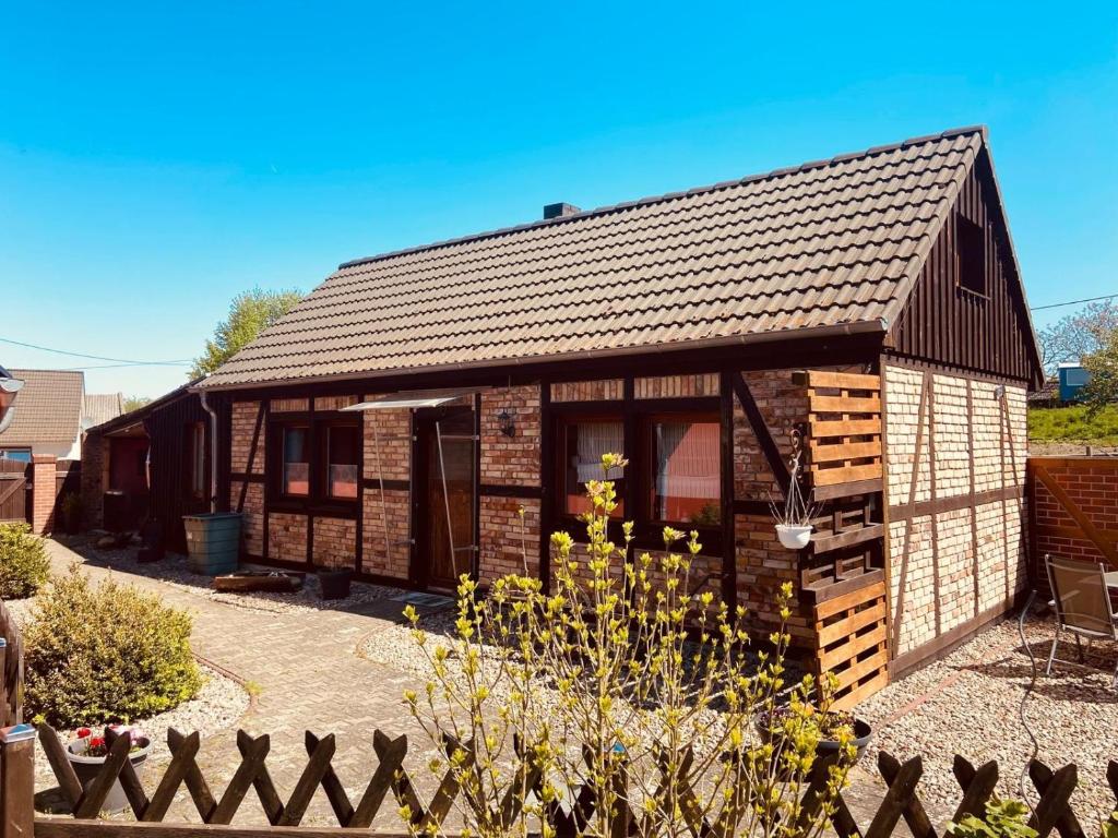 a small brick house with a black roof at Alte Schmiede in Melzow