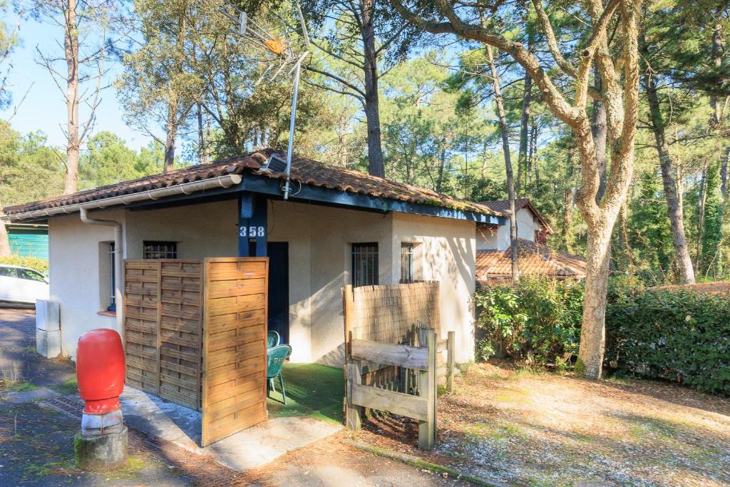 Una pequeña casa con una puerta delante de ella. en Saint Amon, en Moliets-et-Maa