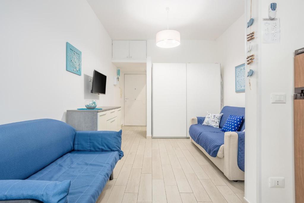 a living room with a blue couch and a tv at Studio Flat Blu Palermo Mondello in Palermo