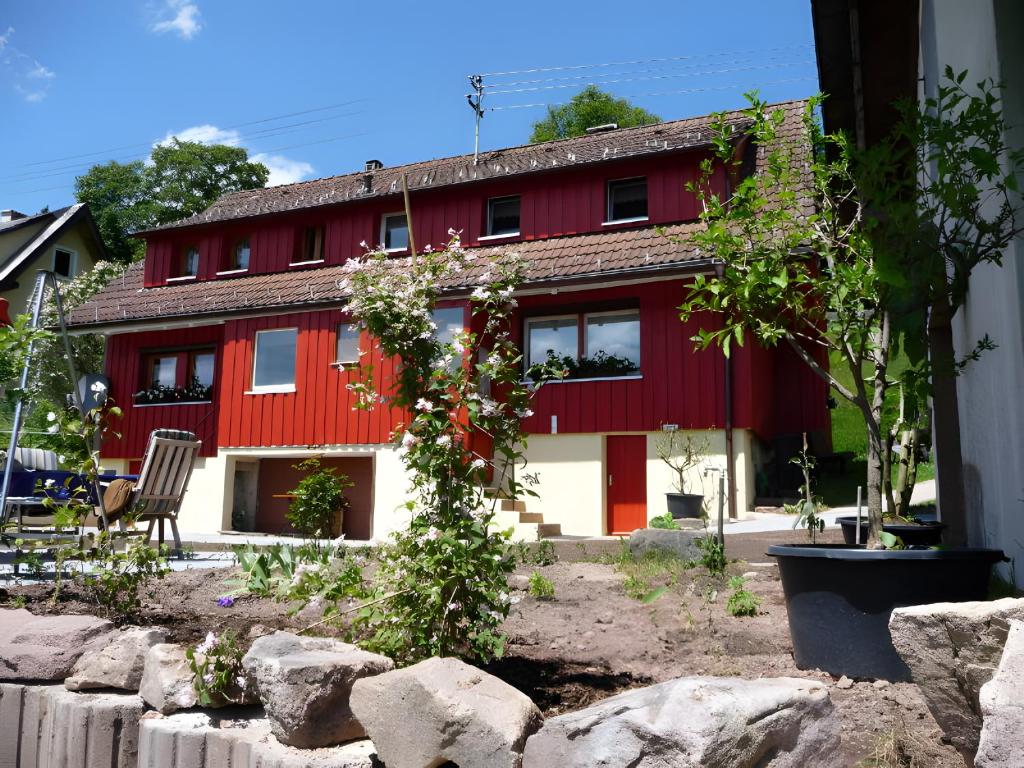 a red house with a tree in front of it at Ferienhaus Elfi Mit 85qm in Eisenbach