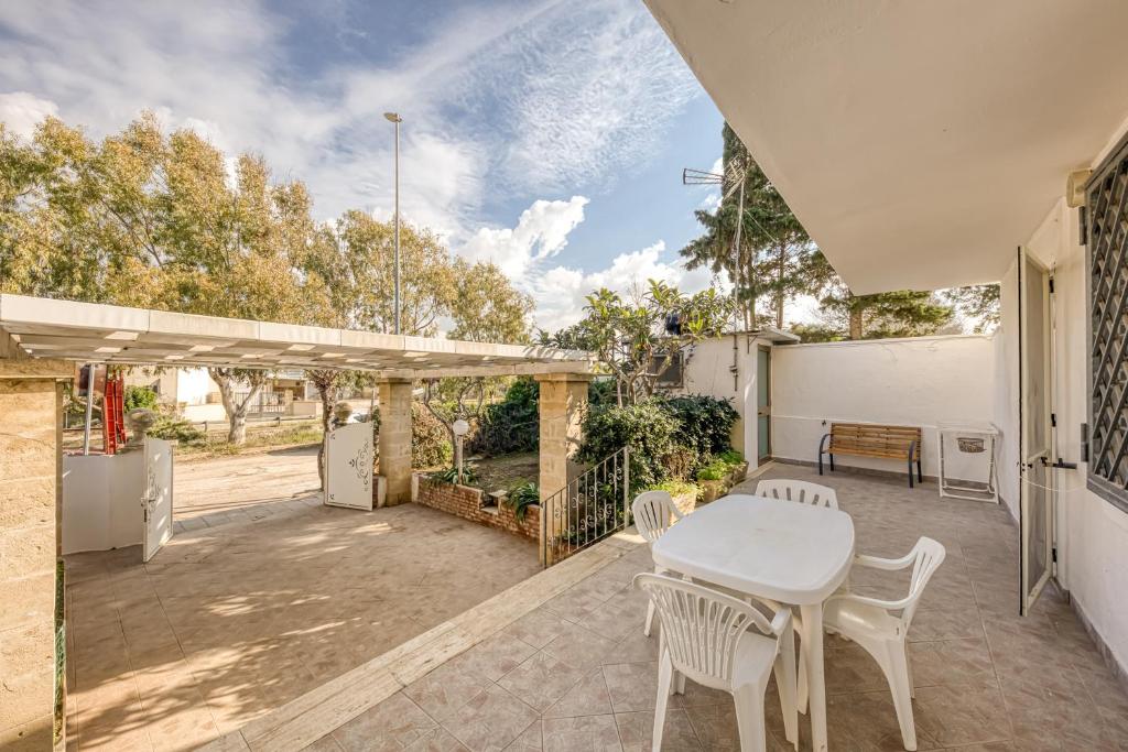 a patio with a white table and chairs at Appartamento Luce sulla spiaggia in Torre San Giovanni Ugento