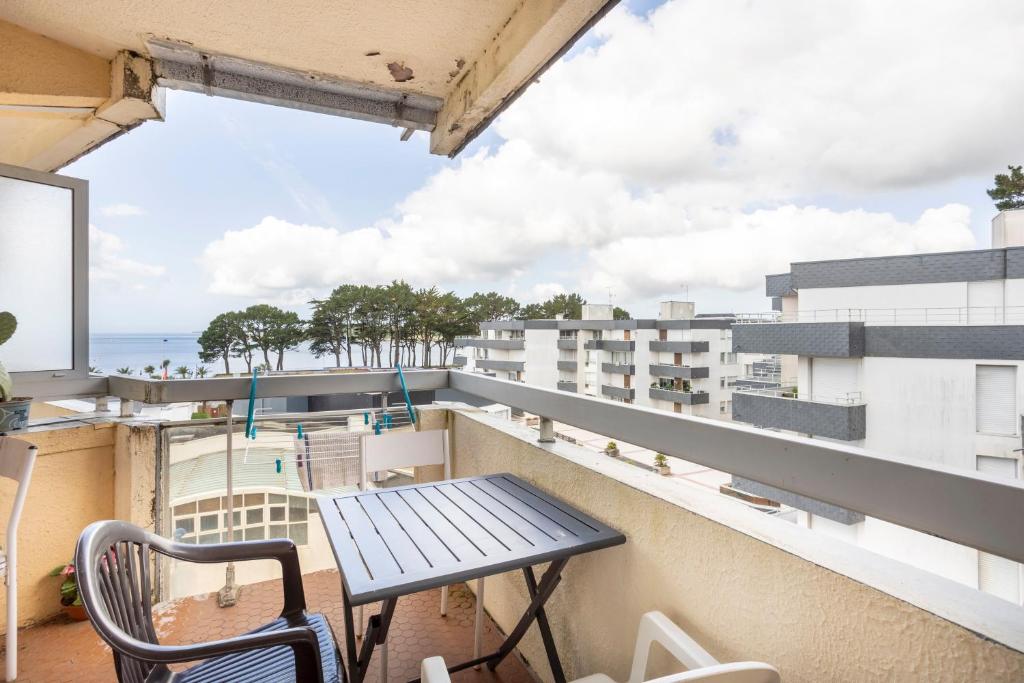 a balcony with a table and chairs and a view of the ocean at Studio vue mer - 50m de la plage in Bénodet