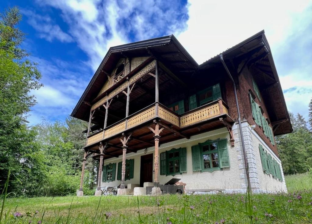 a house with a wooden roof on a field at Haus Tanegg in Innsbruck