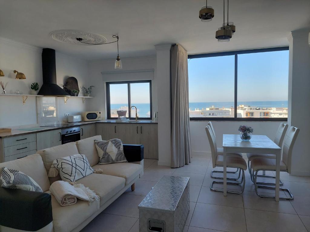 a living room with a couch and a table at Lindo T2 com vista mar in Quarteira