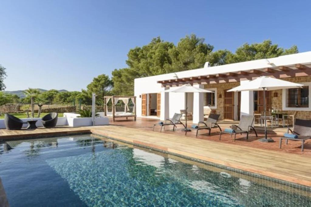 a house with a swimming pool and a patio at Villa Dalt S Era in Santa Gertrudis de Fruitera
