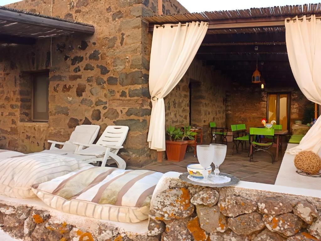a bedroom in a stone house with a bed and a patio at Antico Dammuso Invernale in Pantelleria