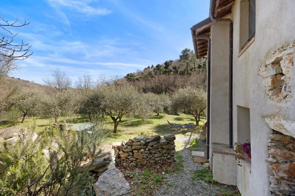 a building with a pile of logs next to a field at Del Fiume in Rialto