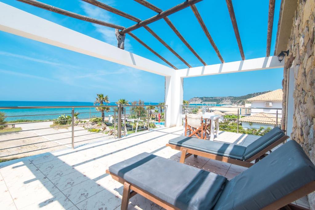 a balcony with a couch and a view of the ocean at Mirage Arillas Honeymoon Studio in Arillas