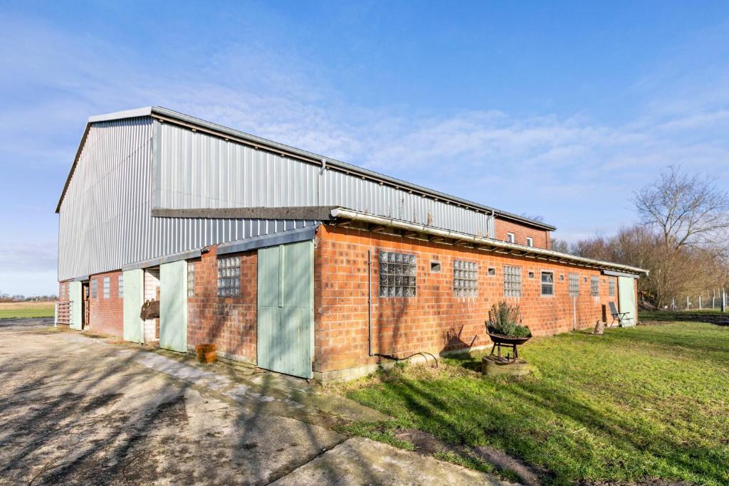 a brick building in a field next to a field at Gutgemacht in Sankt Annen