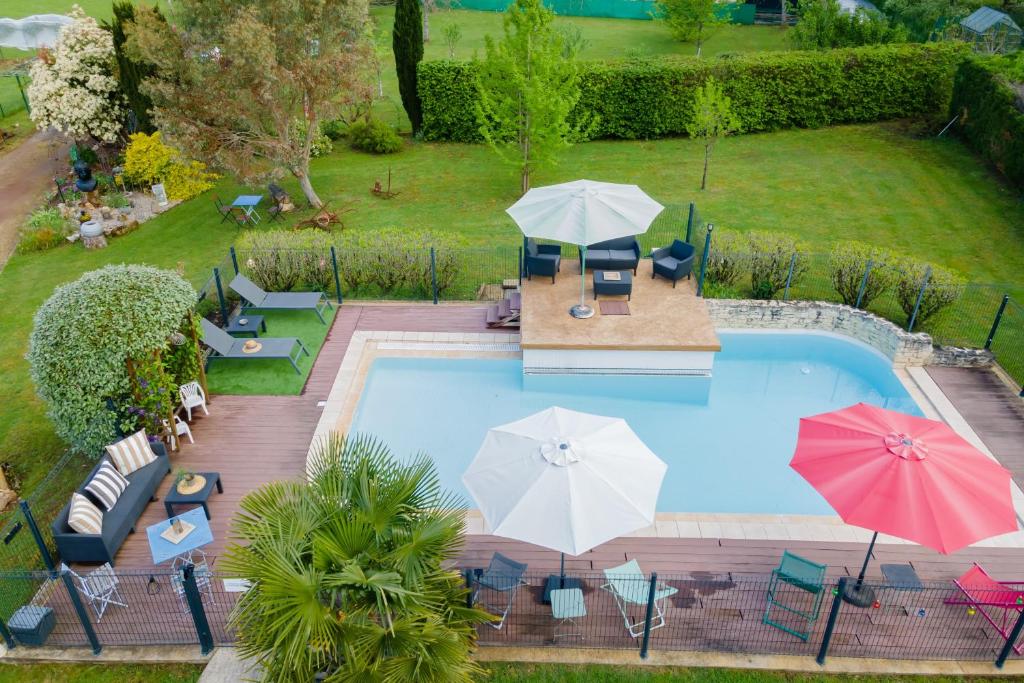 an aerial view of a swimming pool with umbrellas at Maloan, gite avec piscine in Saint-Julien-de-Lampon