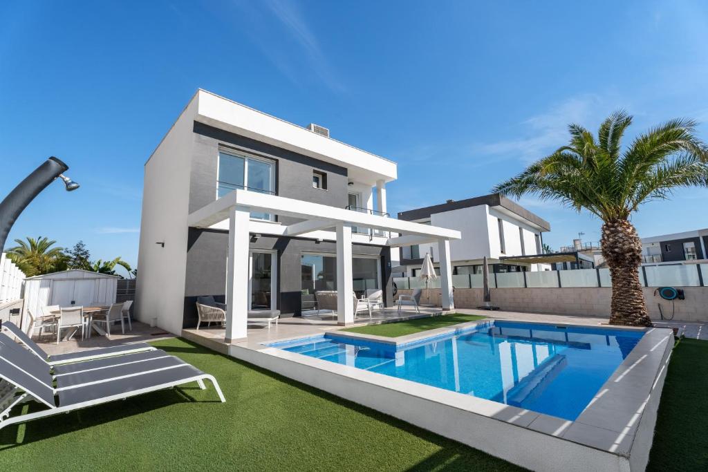 a villa with a swimming pool and a house at Casa Bos Palm Tree Villa with Pool in Gran Alacant
