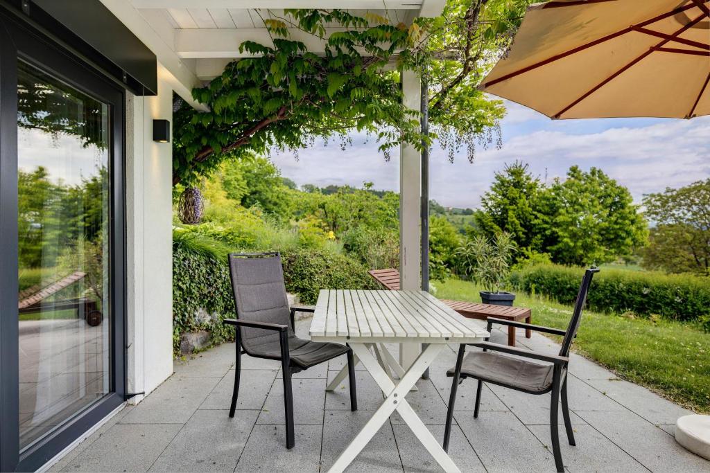 a table and chairs on a porch with an umbrella at Ferienwohnung Frieda in Frickingen