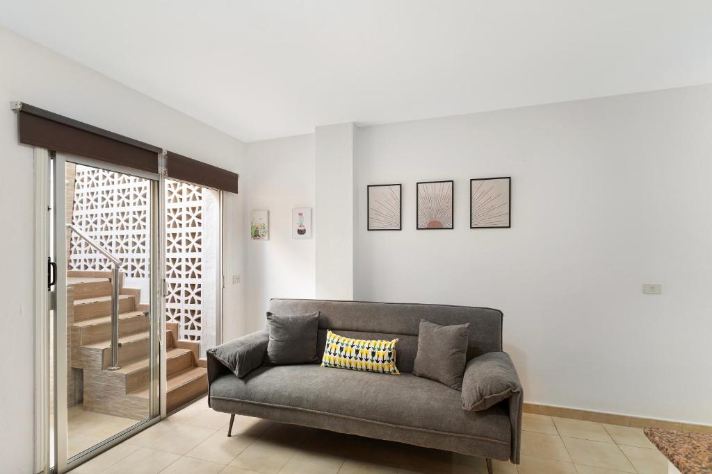 a living room with a couch and a staircase at Apartamento Danoe 3 in Mogán