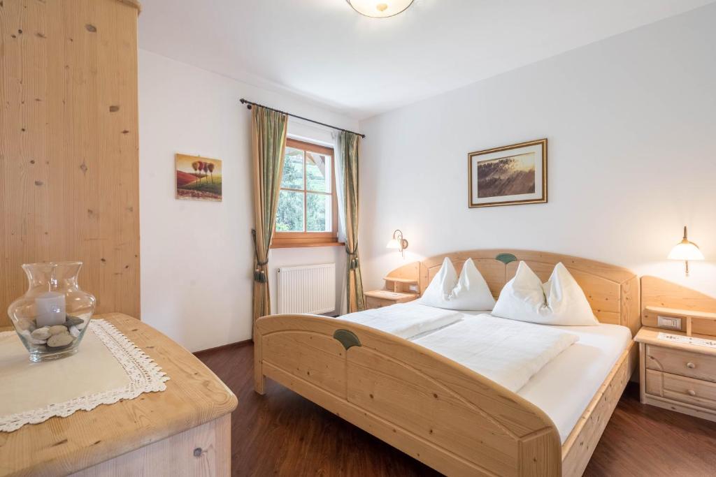 a bedroom with a large bed with white sheets at Tischlerhof - Typ B mit Terrasse in Tirolo