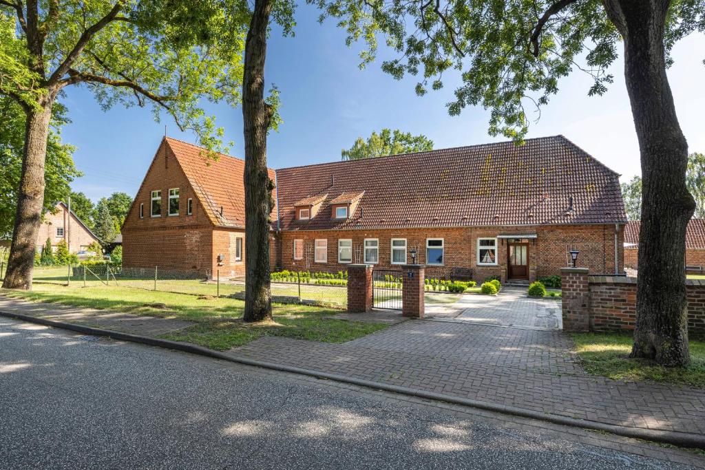 a brick house with trees in front of it at Landhaus Heiddorf in Neu Kaliß