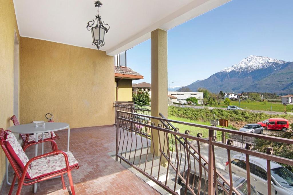 a balcony with a table and chairs and mountains at Gravedona Lake Como in Consiglio di Rumo