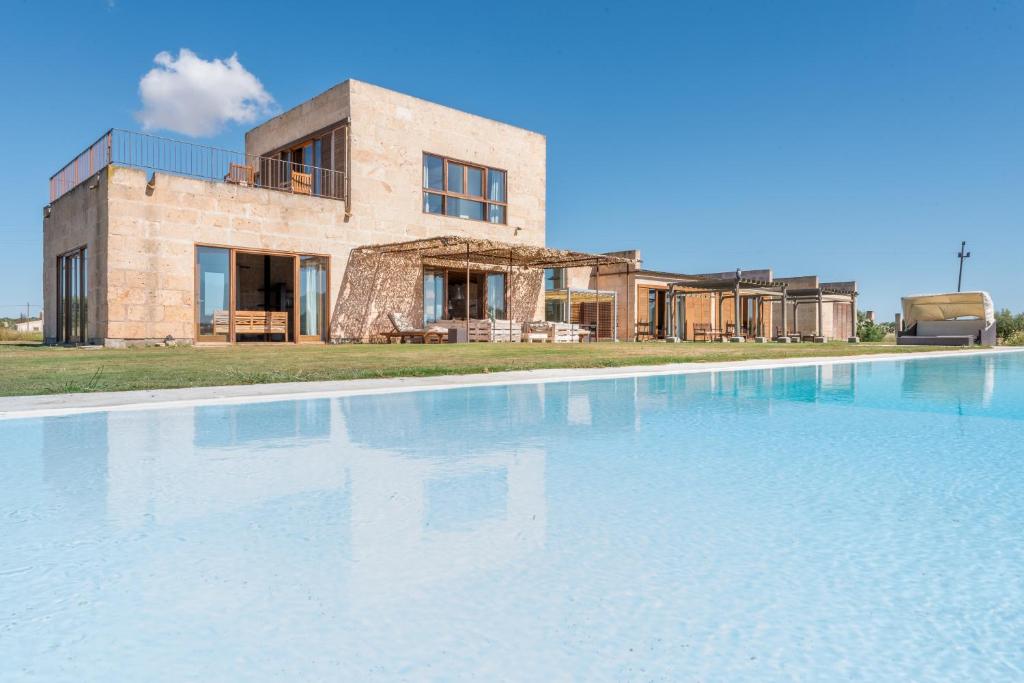 a large swimming pool in front of a house at Son Coranta in Campos