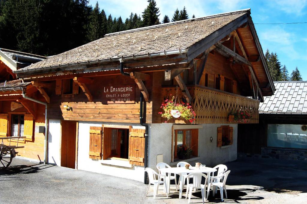 a building with a table and chairs in front of it at Chalet La Grangerie in Montriond