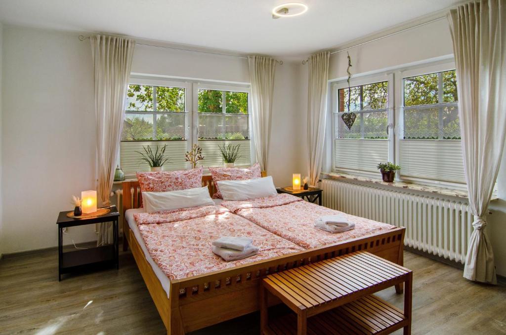 a bedroom with a large bed with two windows at Haus Scheve in Rhauderfehn