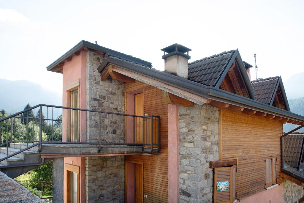 a house with a balcony on the side of it at Il Piccolo Sogno in Temù