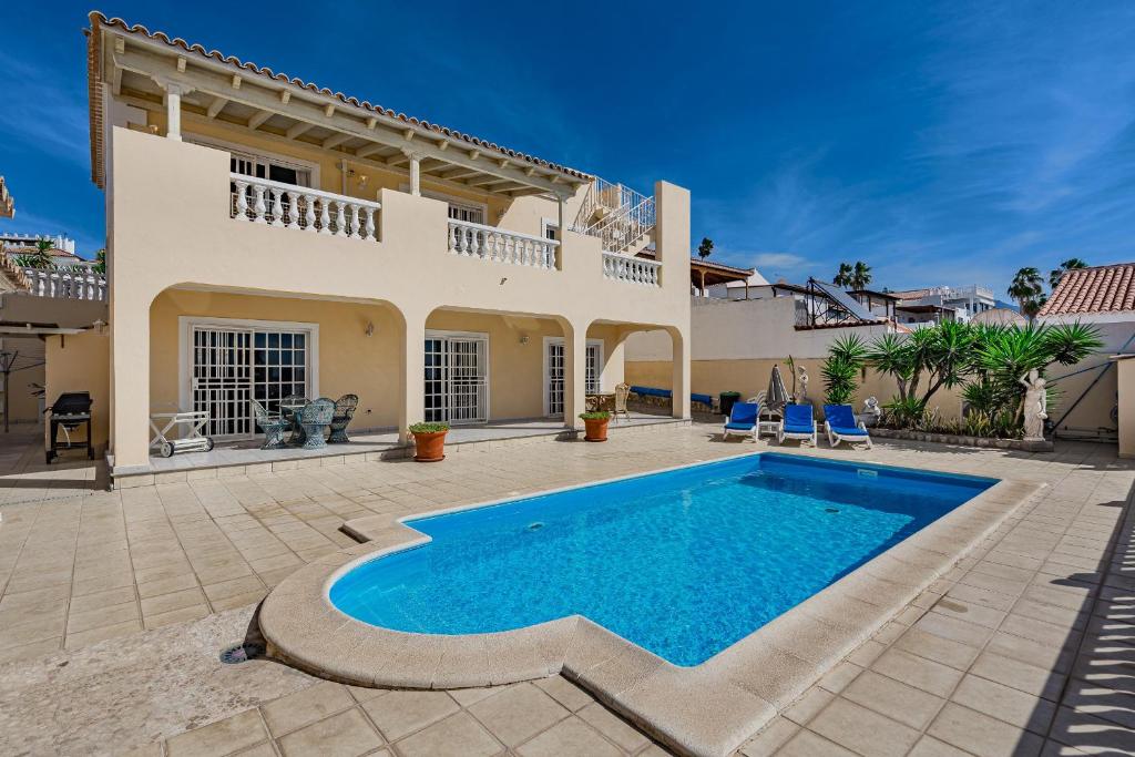 a villa with a swimming pool in front of a house at Villa el Yuka , heated pool in Callao Salvaje