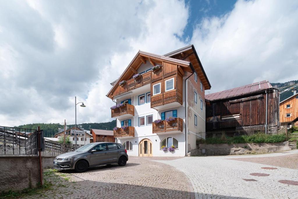 a house with a car parked in front of it at Piaz de Vich in Vigo di Fassa