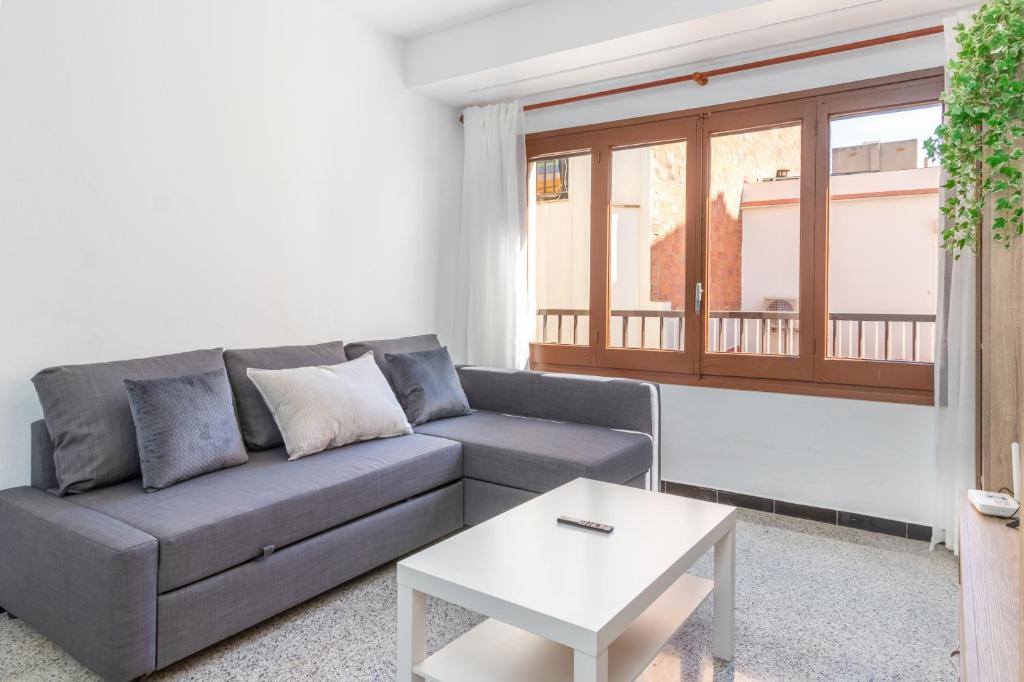 a living room with a couch and a table at Can Lopits in L'Escala