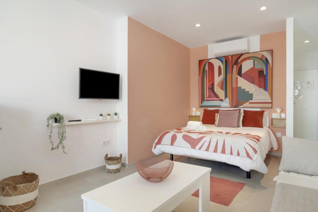 a bedroom with a bed and a tv on a wall at Apartamento The Stairs 2 11 in Tarifa