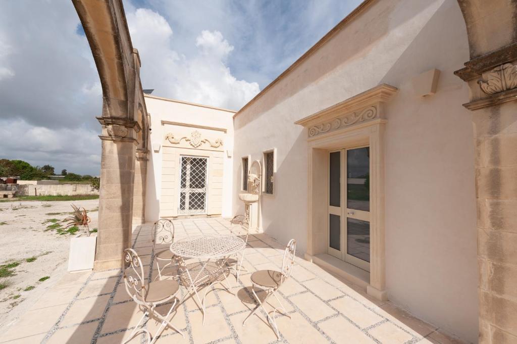 a patio with a table and chairs on a building at Anghelos in Lizzanello