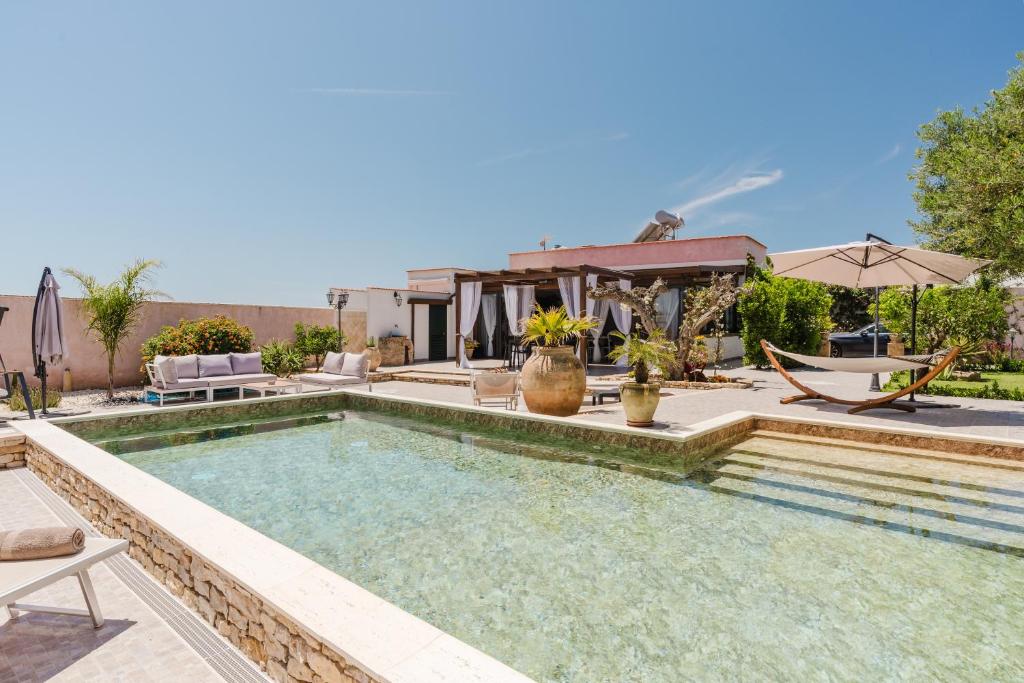 a swimming pool in the backyard of a house at Le Giarre - Villa Con Piscina in Marausa