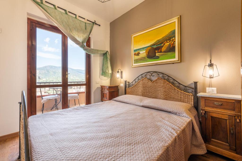a bedroom with a bed and a large window at Solemarevacanze Villasimius in Villasimius