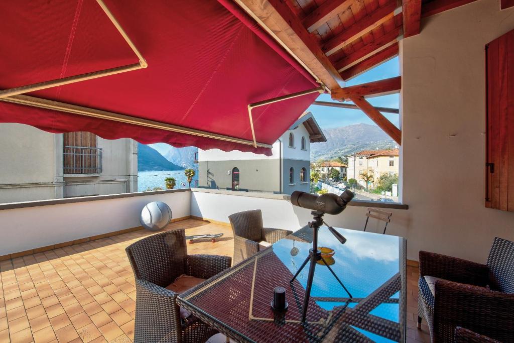 a dining room with a glass table and a red umbrella at Wakesurfhouse 2 in Sulzano