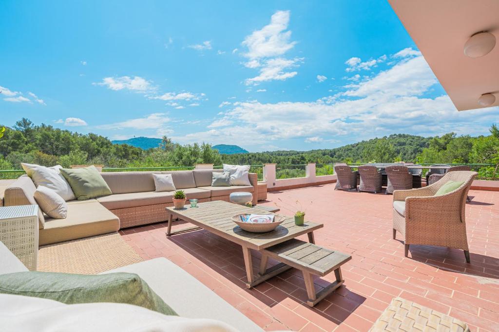a patio with a couch and a table and chairs at Villa Son Bibiloni in Algaida