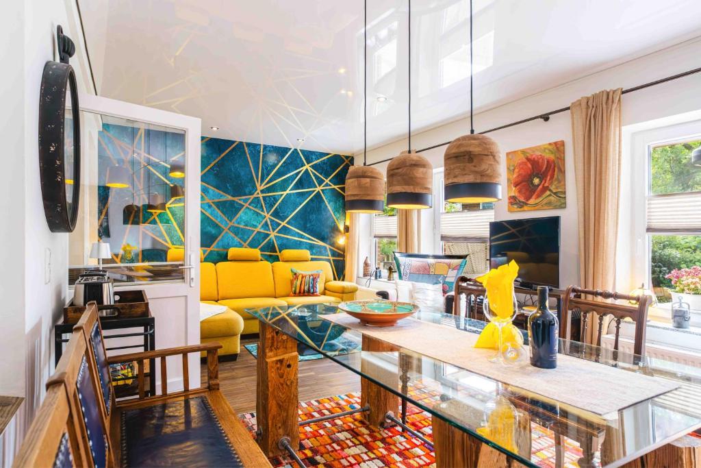 a living room with a table and a yellow couch at Treibholz - Feriendomizil Ostsee in Schönberger Strand