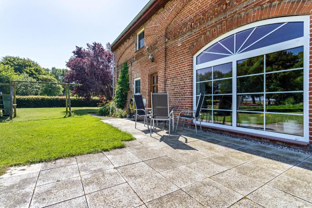 a patio with two chairs in front of a brick building at Kranichblick in Lüdershagen