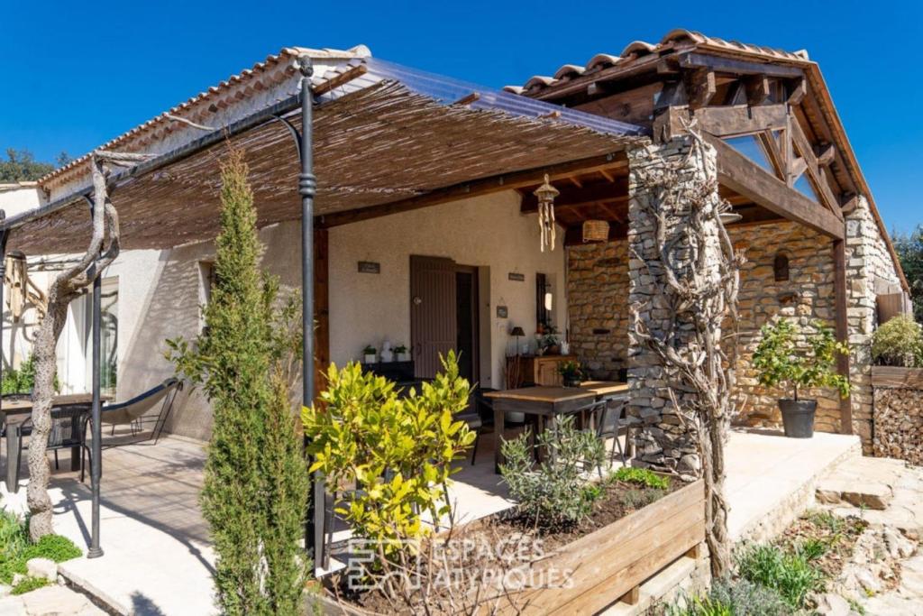 a stone cottage with a table in a garden at La Petite Maison De Noémie in Gras
