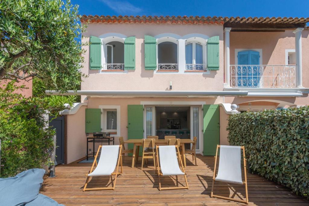 a patio with chairs and a house at Villa Alpaga Esterel Vue Mer in Saint-Raphaël