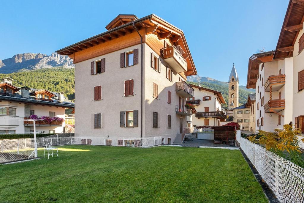 a large building with a green lawn in front of it at Mansarda Combo in Bormio