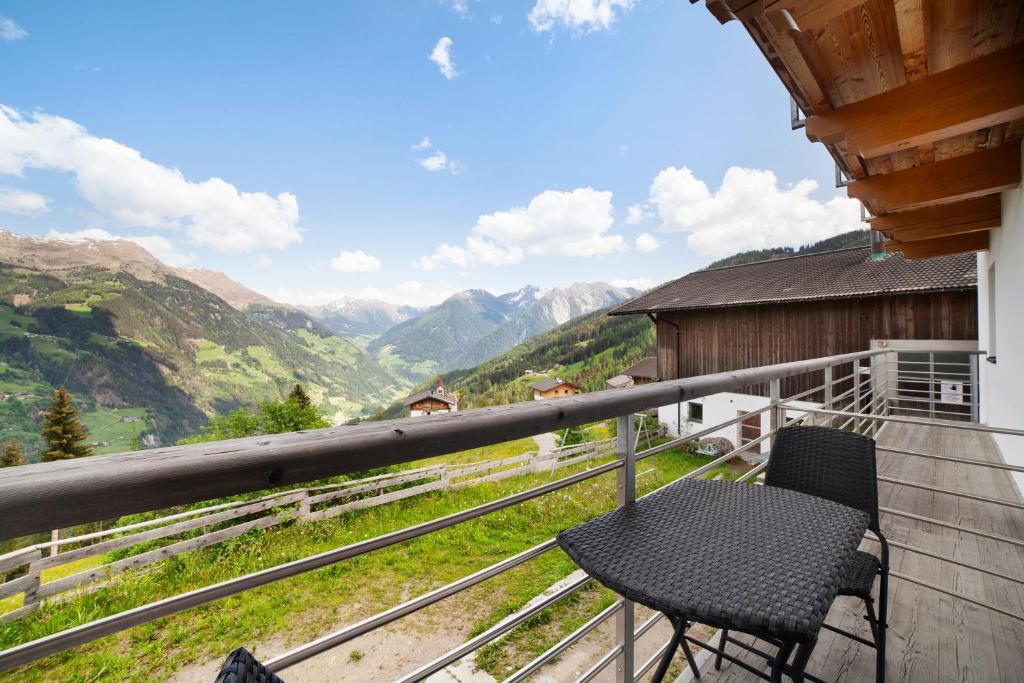 a balcony with two chairs and a view of mountains at Joshof Talblick in Moso