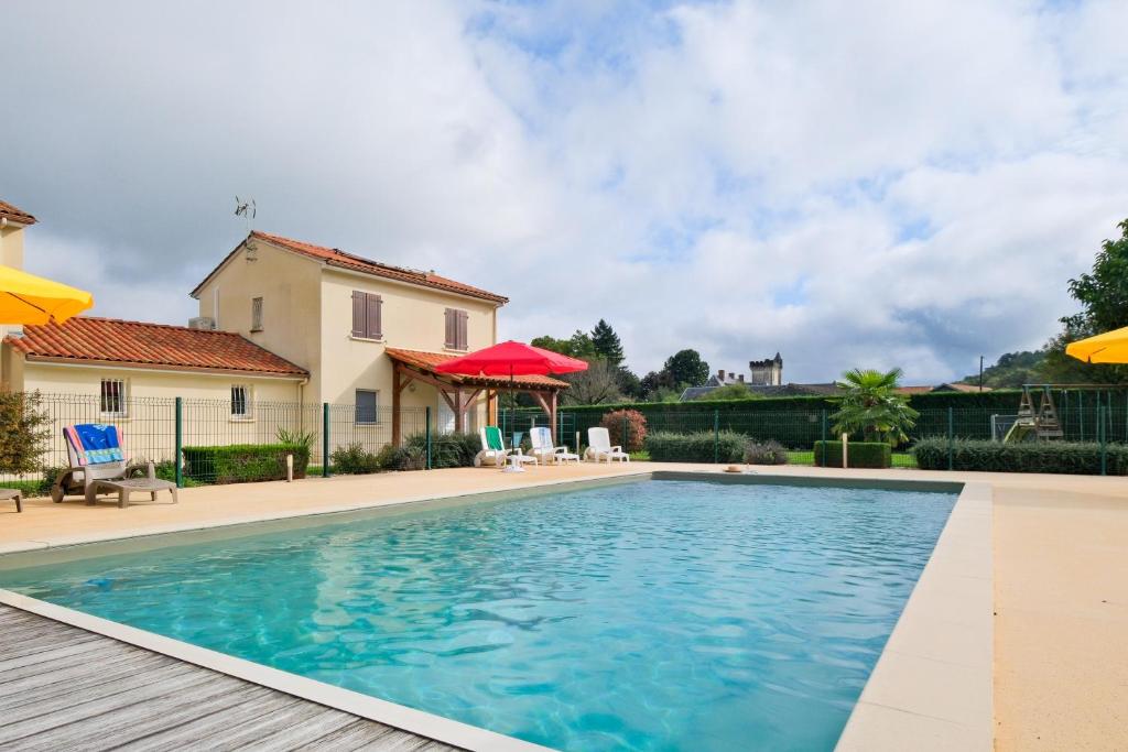 a swimming pool in front of a house at Le Perchoir Avec Piscine et Clim in Savignac-les-Églises